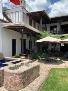 a building with a patio with tables and umbrellas at Villa de Antaño in Antigua Guatemala