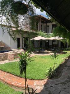 een huis met een tuin met palmbomen ervoor bij Villa de Antaño in Antigua Guatemala