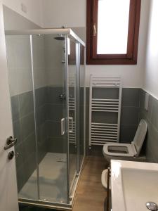 La salle de bains est pourvue d'une douche en verre et de toilettes. dans l'établissement Casa Mestrina, à Mestre