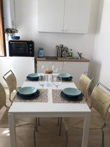 a kitchen with a white table with plates and wine glasses at Casa Mestrina in Mestre