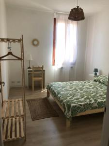 1 dormitorio con 1 cama, 1 silla y 1 ventana en Casa Mestrina, en Mestre