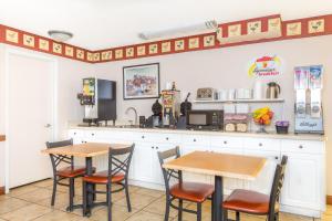 two tables and chairs in a kitchen with a counter at Super 8 by Wyndham Salina/Scenic Hills Area in Salina