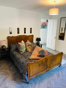 a large bed with a wooden frame in a bedroom at Funky cozy cottage with outside space in Eastbourne