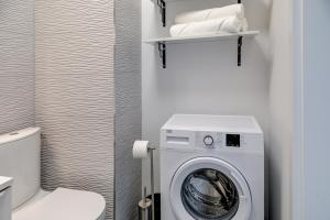 a washing machine in a bathroom with a toilet at Modern Apt near Old Town - King Bed - Free Parking in Poznań