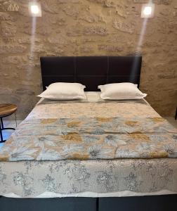 uma cama com uma cabeceira preta e duas almofadas em Le Cherche Midi - Appartement centre historique d'Uzès em Uzès