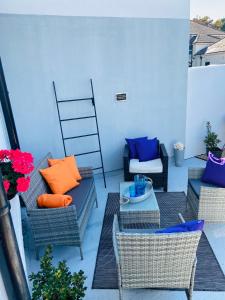 un patio con sofás, mesa y sillas en Funky cozy cottage with outside space en Eastbourne