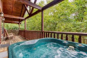 a jacuzzi tub on a porch of a cabin at Always Kiss Me Goodnight-Get 951 worth of FREE area attraction tickets for each paid day!!! in Pigeon Forge