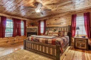 a bedroom with a bed in a log cabin at Always Kiss Me Goodnight-Get 951 worth of FREE area attraction tickets for each paid day!!! in Pigeon Forge