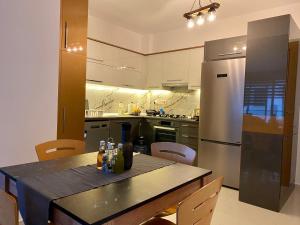 a kitchen with a table and a stainless steel refrigerator at Luxurious Brand New Apartment in the City Centre in Kyrenia