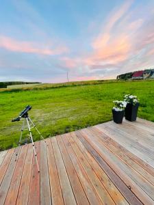 una cámara en un trípode sobre una cubierta de madera en Romantyczny domek dla dwojga en Jabłonka