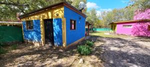 a blue and yellow tiny house in a yard at Casita de Colores in Cosquín