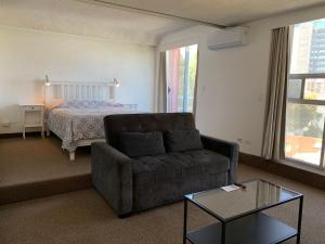 a living room with a couch and a bed at Dali Suites in Tijuana