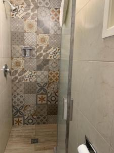 a shower with a glass door in a bathroom at Dali Suites in Tijuana