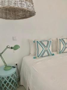 um quarto com uma cama com um candeeiro e almofadas em Cosy Home no Porto