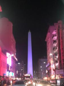 a lit up obelisk in a city at night at Las Naciones 1710 in Buenos Aires