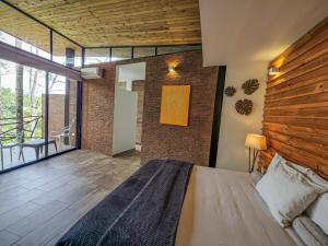 1 dormitorio con 1 cama grande y balcón en HOTEL MADEIRA BOUTIQUE, en Doradal