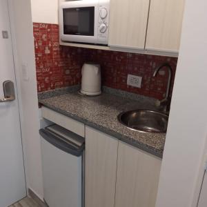 a small kitchen with a sink and a microwave at Las Naciones 1710 in Buenos Aires