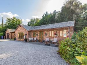 un cottage in mattoni con sedie e tavoli nel vialetto di Wild Duck Lodge a Rufford