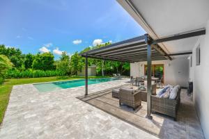 um pátio exterior com uma piscina e um toldo em Awesome 4 Bedroom HouseW/Pool @Westchester Miami em Tamiami