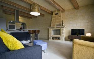 un soggiorno con divano e camino di Villa Boomerang a Għasri