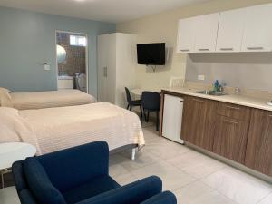 a bedroom with a bed and a kitchen with a sink at Dali Suites in Tijuana