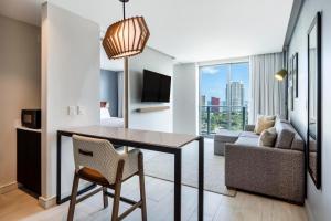 Atwell Suites - Miami Brickell, an IHG Hotel في ميامي: غرفة معيشة مع طاولة طعام وأريكة