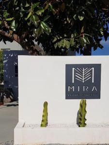a sign for a mirea insurance company next to a cactus at Mira Living Concept Suites Adults Only in Kokkíni Khánion