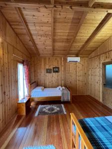 a bedroom with a bed in a wooden cabin at Blen Grand in Berat