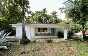 a white house with a palm tree in front of it at Villa Montana in Contadora