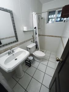 a white bathroom with a sink and a toilet at Villa Montana in Contadora