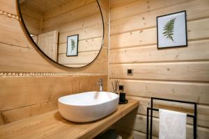ein Badezimmer mit einem weißen Waschbecken und einem Spiegel in der Unterkunft Ovis Homes in Zawoja