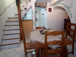 una sala da pranzo con tavolo, sedie e scale di charmante maison de village a Saint-Jean-du-Bruel