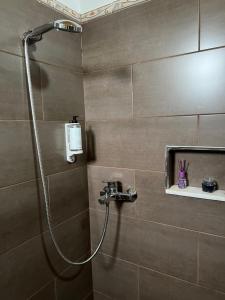 a bathroom with a shower with a shower head at Blen Grand in Berat