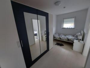 a room with a door with a bed and a mirror at 2 modern private rooms with private Balcon fits for 5 persons in Vichten