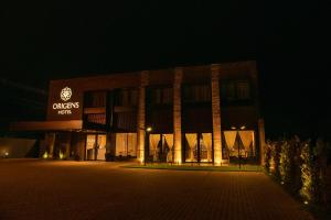 サン・ルイス・ゴンザーガにあるOrigens Hotelの夜に正面に看板が掲げられた建物