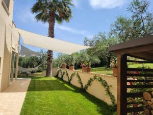 a backyard wedding with a white canopy and a palm tree at Casale Angela in Torrevecchia Teatina