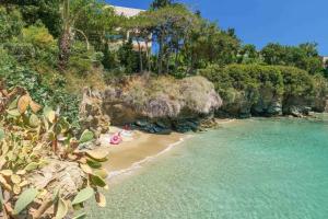 a beach with people laying on the sand and the water at Eva Studios & Apartments in Agia Pelagia