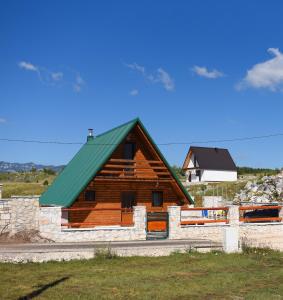 Un gran edificio de madera con techo verde. en Gora Home 9, en Žabljak