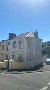 a white house on the side of a street at The Bonting beautiful three bed townhouse near harbour and beach in Torquay