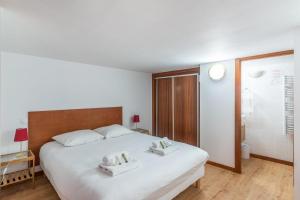 a bedroom with a large white bed with two pillows on it at Very nice duplex located on the main square - Toulouse - Welkeys in Toulouse