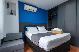 a bedroom with a bed and a blue wall at Apartamento especial- Icarai Niterói in Niterói