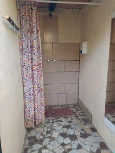 a shower curtain in a bathroom with a tiled floor at Casa Arbol Domos in Cafayate