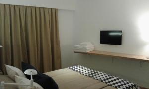 una habitación de hotel con TV en la pared en Hotel Bariloche Flat en San Carlos de Bariloche