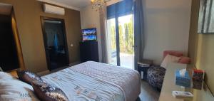 a bedroom with a bed and a sliding glass door at Appartement luxe Taghazout bay - mer & piscine in Agadir +28 photos