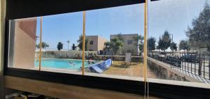 a view of a swimming pool from a window at Appartement luxe Taghazout bay - mer & piscine in Agadir