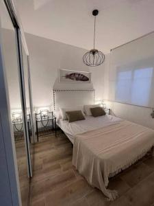 sypialnia z dużym łóżkiem w białym pokoju w obiekcie Apartamento céntrico y en primera línea de playa w mieście Benidorm
