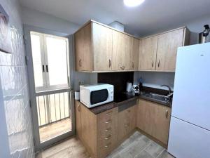 małą kuchnię z kuchenką mikrofalową i lodówką w obiekcie Apartamento céntrico y en primera línea de playa w mieście Benidorm