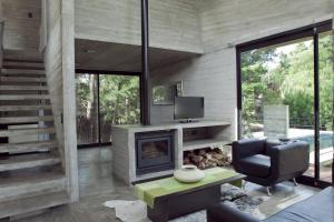 a living room with a fireplace and a chair at V & D - Casas en Mar Azul in Mar Azul