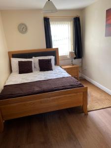 a bedroom with a large wooden bed with a window at Fife Apartments in Dunfermline