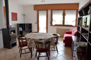 - un salon avec une table et un canapé rouge dans l'établissement Appartamento Giada Pozzale di Pieve di Cadore(BL), à Pieve di Cadore